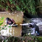 Students measuring water level outside of London