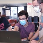 Jiaheng Zhang (left) and Rolando Rodarte (center) ask Laboratory for Manufacturing and Production Manager Joseph Wight (right) for feedback on a CAD model.